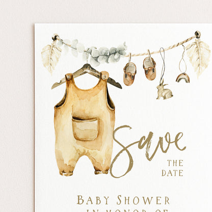 The image is a watercolor painting of a baby's outfit hanging on a hanger, with a pair of shoes and a rabbit nearby. The painting is accompanied by the text "Save the date" and "Baby shower in honor of"