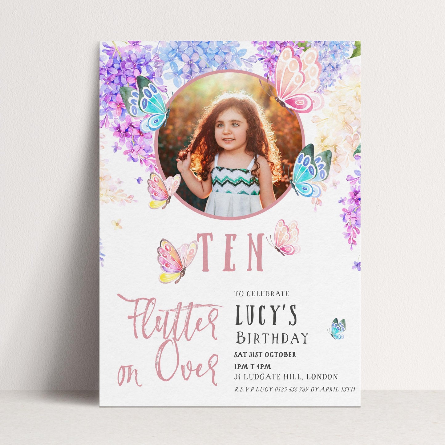 A birthday invitation for a young girl named Lucy, featuring a photo of her surrounded by colorful butterflies and flowers.