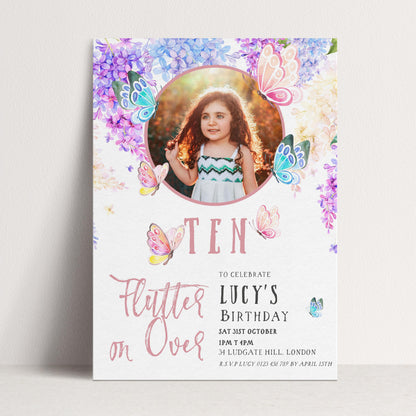 A birthday invitation for a young girl named Lucy, featuring a photo of her surrounded by colorful butterflies and flowers.