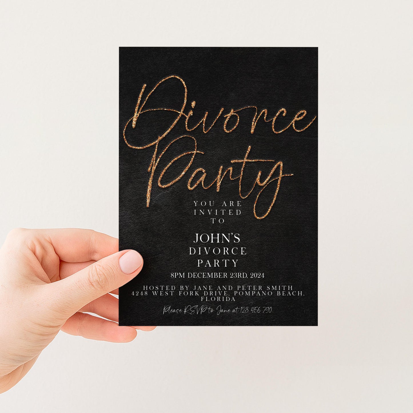 a person holding a black invitation card with gold text and details about a party.