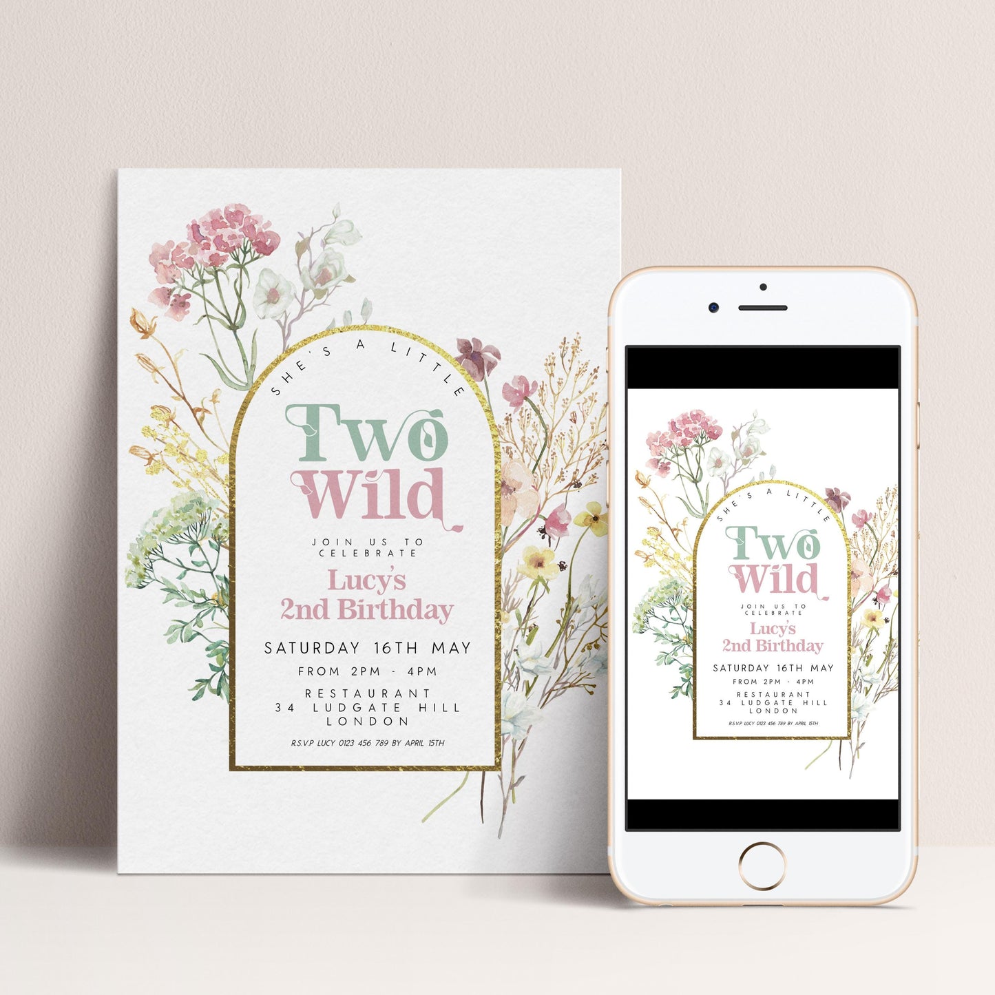 The image is a birthday invitation for a girl named Lucy's second birthday. It is a white card with a floral design and text inviting guests to a celebration. The invitation is accompanied by a smartphone displaying a similar design and text, suggesting a digital version of the printed card.