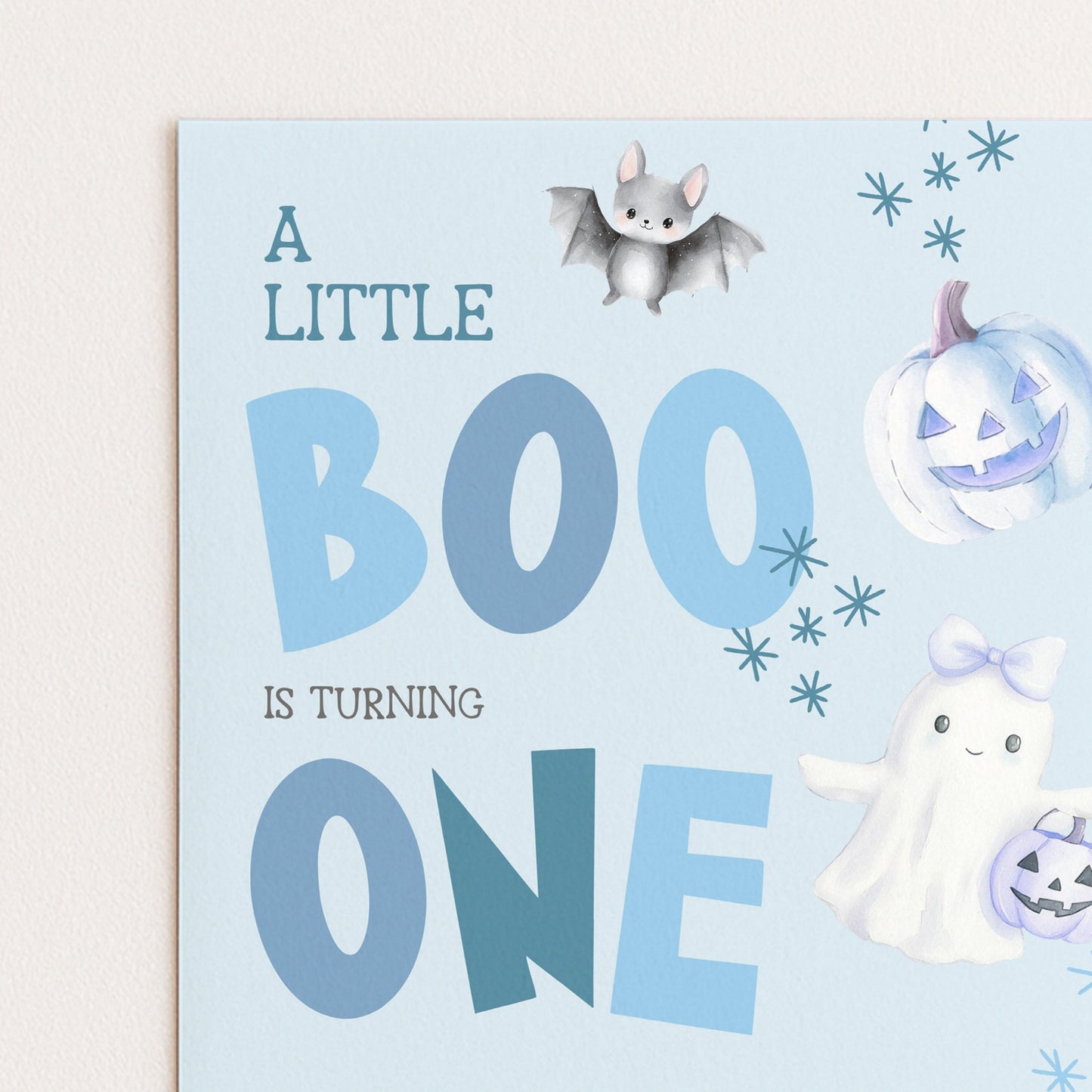A birthday card with a bat, pumpkin, and ghost, along with the text "A LITTLE BOO is TURNING ONE"