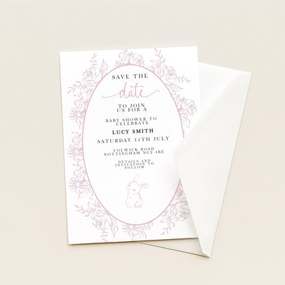 The image is a white invitation card with pink floral designs and text, inviting guests to a baby shower for Lucy Smith.