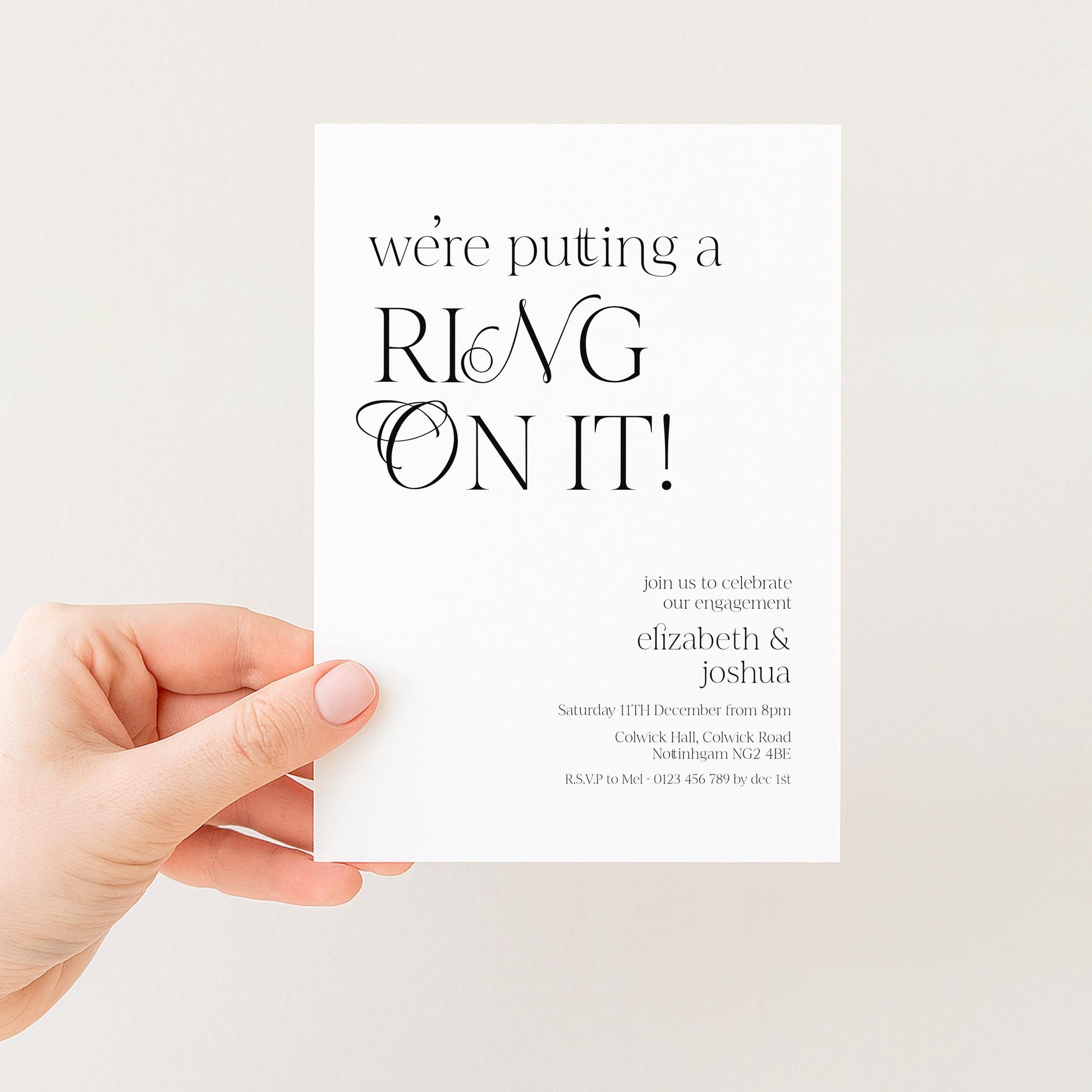 a person's hand holding a white invitation card with black text.