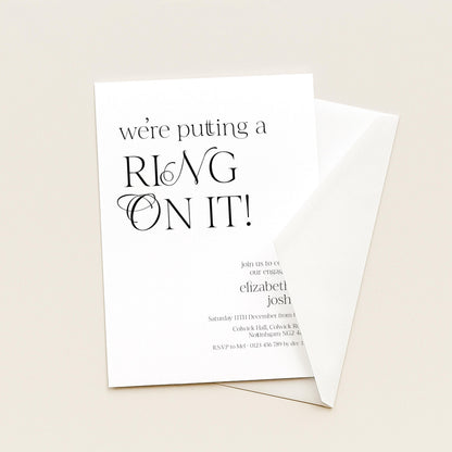 The image is a wedding invitation card with the text "we're putting a ring on it!" The card is white and has a black font.