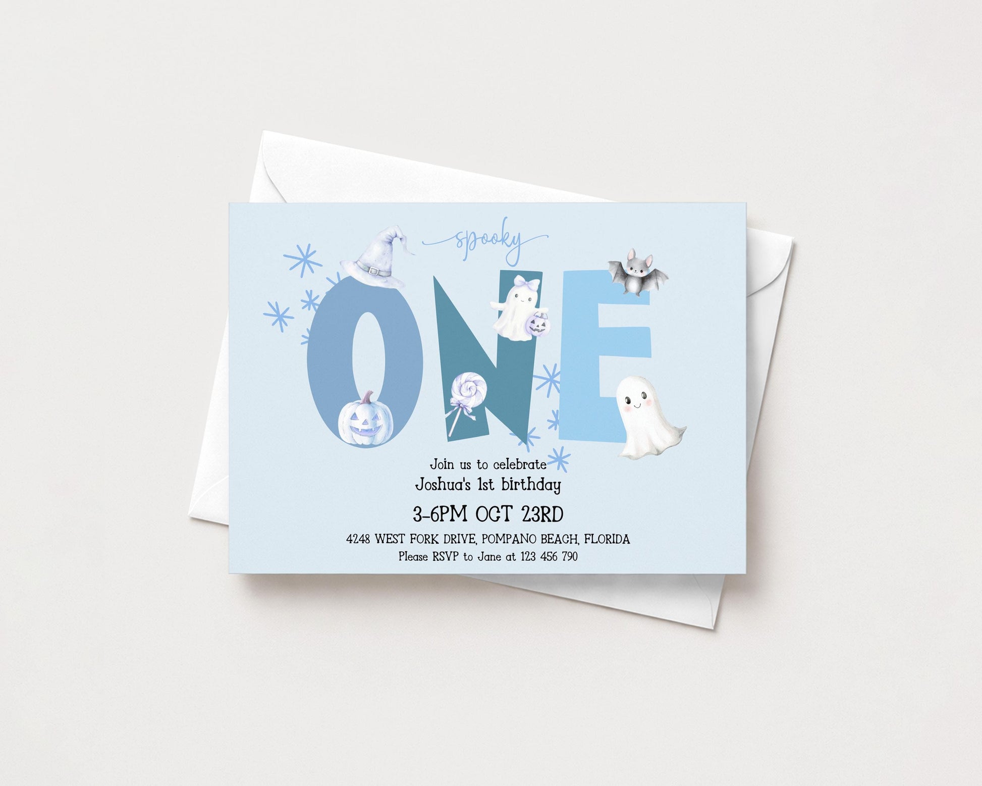 The image is a birthday invitation for a one-year-old, celebrating Joshua's first birthday. The invitation is set against a light blue background and features various Halloween-themed illustrations, including a bat, ghost, and pumpkin.