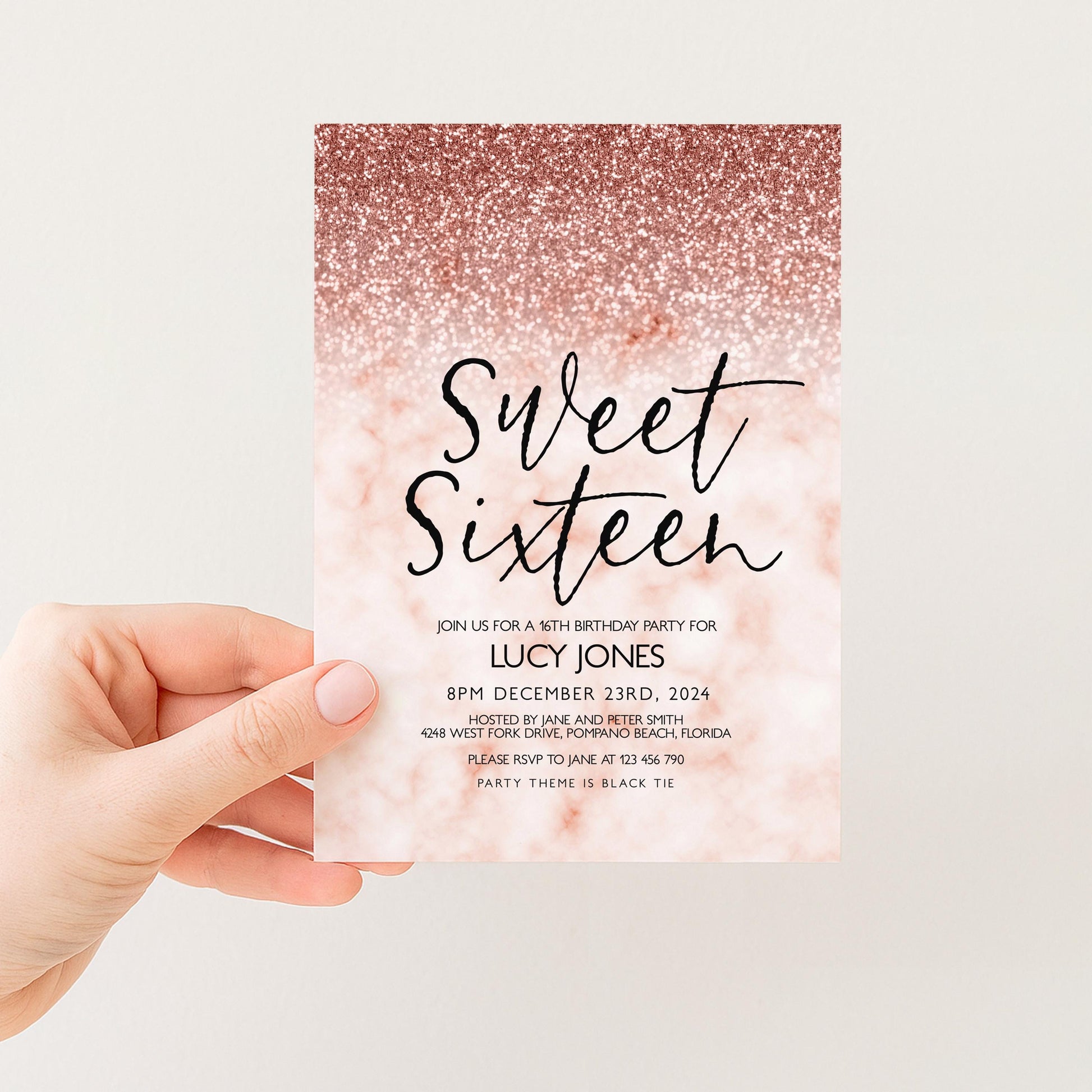 a hand holding a pink and gold glittery invitation card for a 16th birthday party.