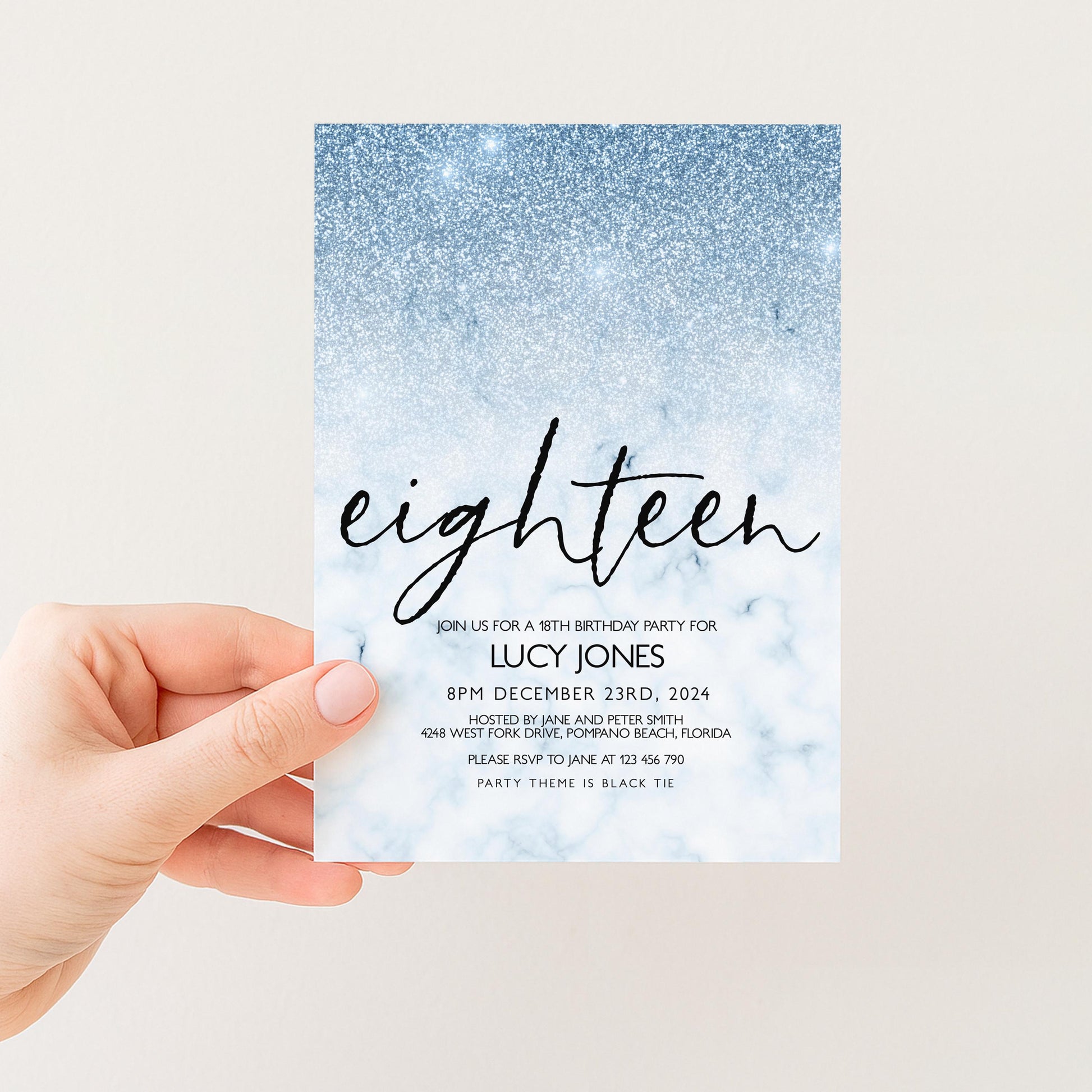 A hand holding a blue and white invitation card for a birthday party.