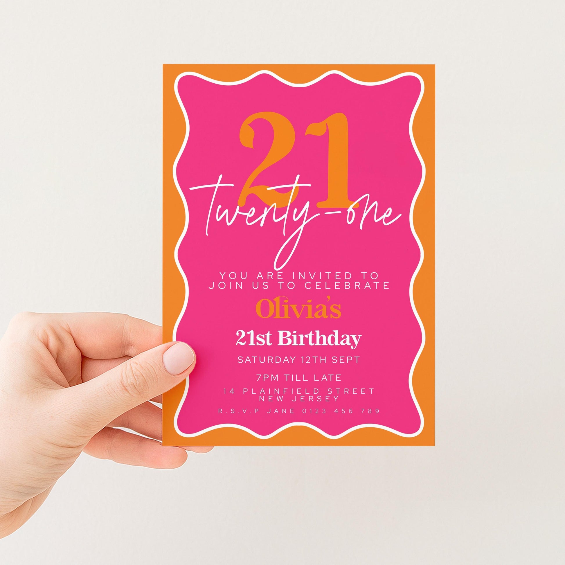 A hand holding a pink and orange birthday invitation card for a 21st birthday celebration.