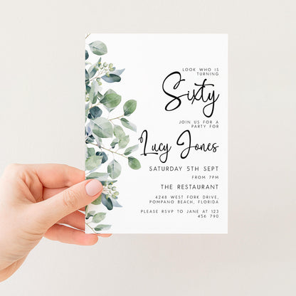 a hand holding a white invitation card with a green leaf design. The card is for a 60th birthday party and includes details about the event, such as the date, time, location, and contact information.