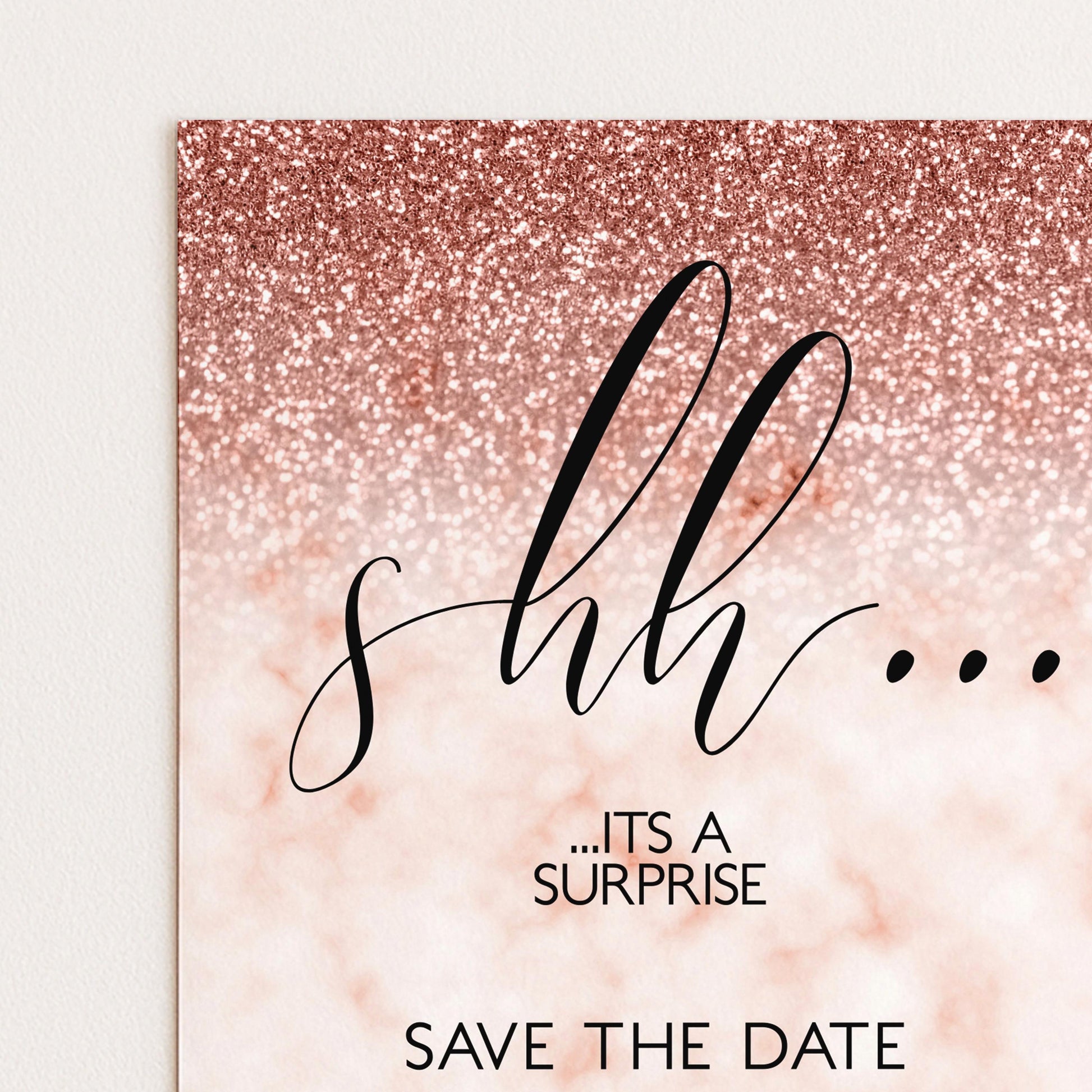 a pink glittery background with the text "s... hh.... it's a surprise.... SAVE THE DATE" written in a cursive font.