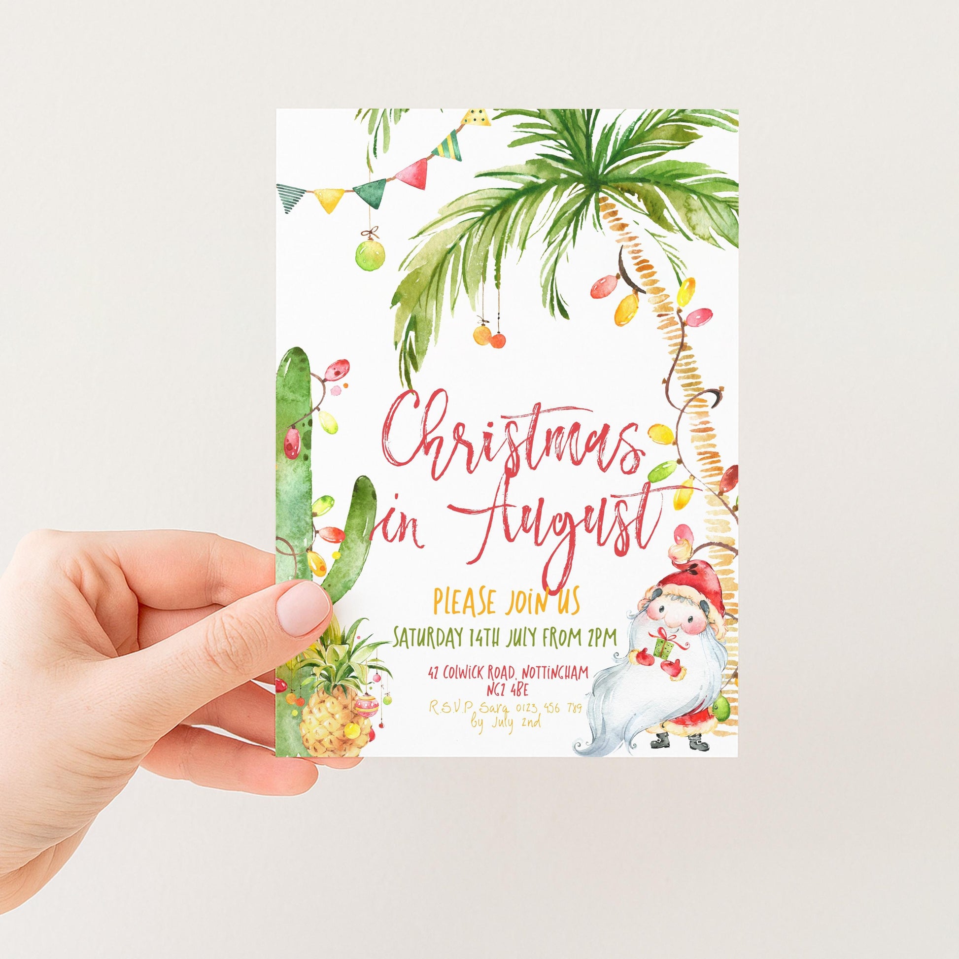 A hand holding a Christmas invitation card with a tropical theme, featuring palm trees, a cactus, and other festive decorations.