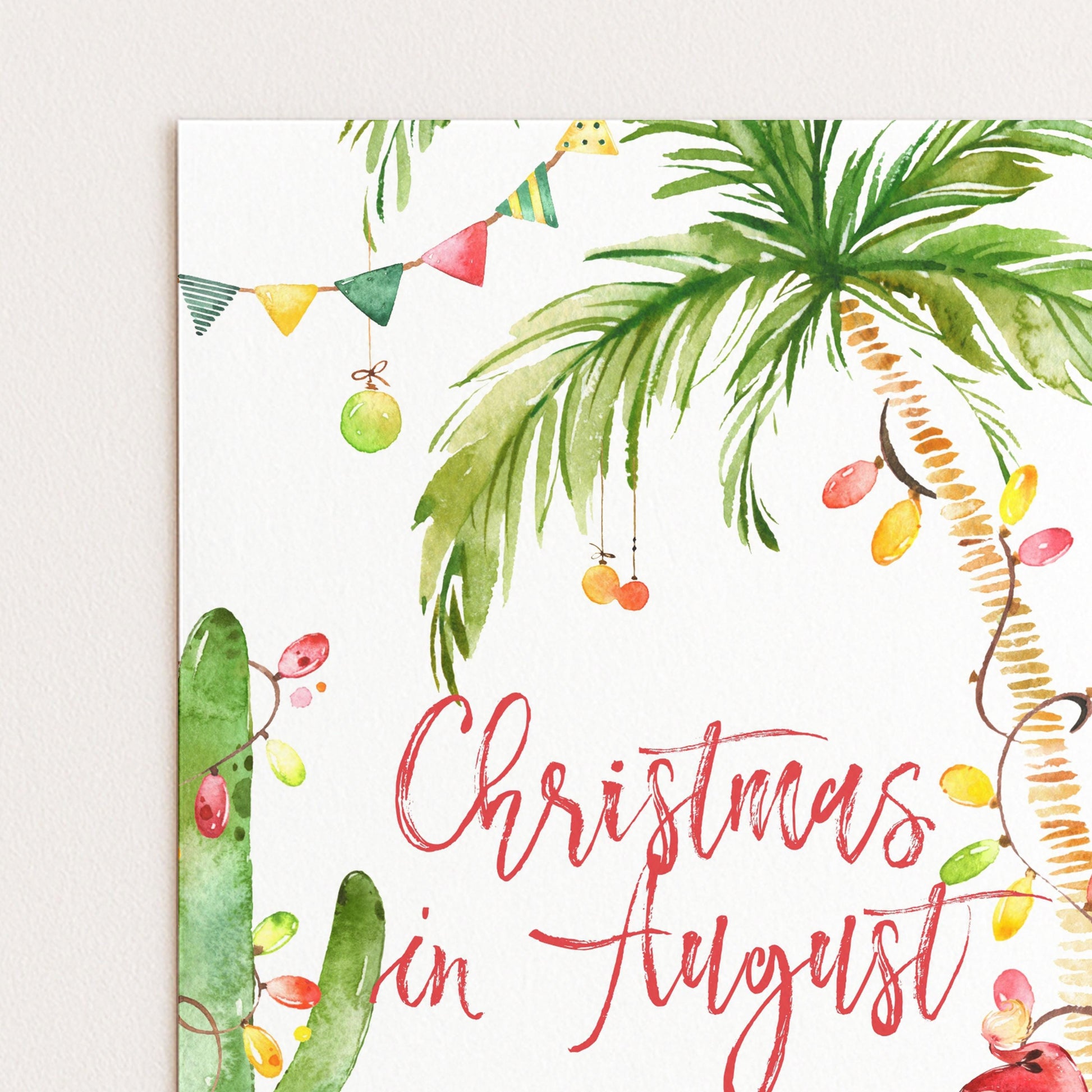 A watercolor painting of a palm tree with colorful ornaments and a banner, along with the text "Christmas in August" written in a decorative font.