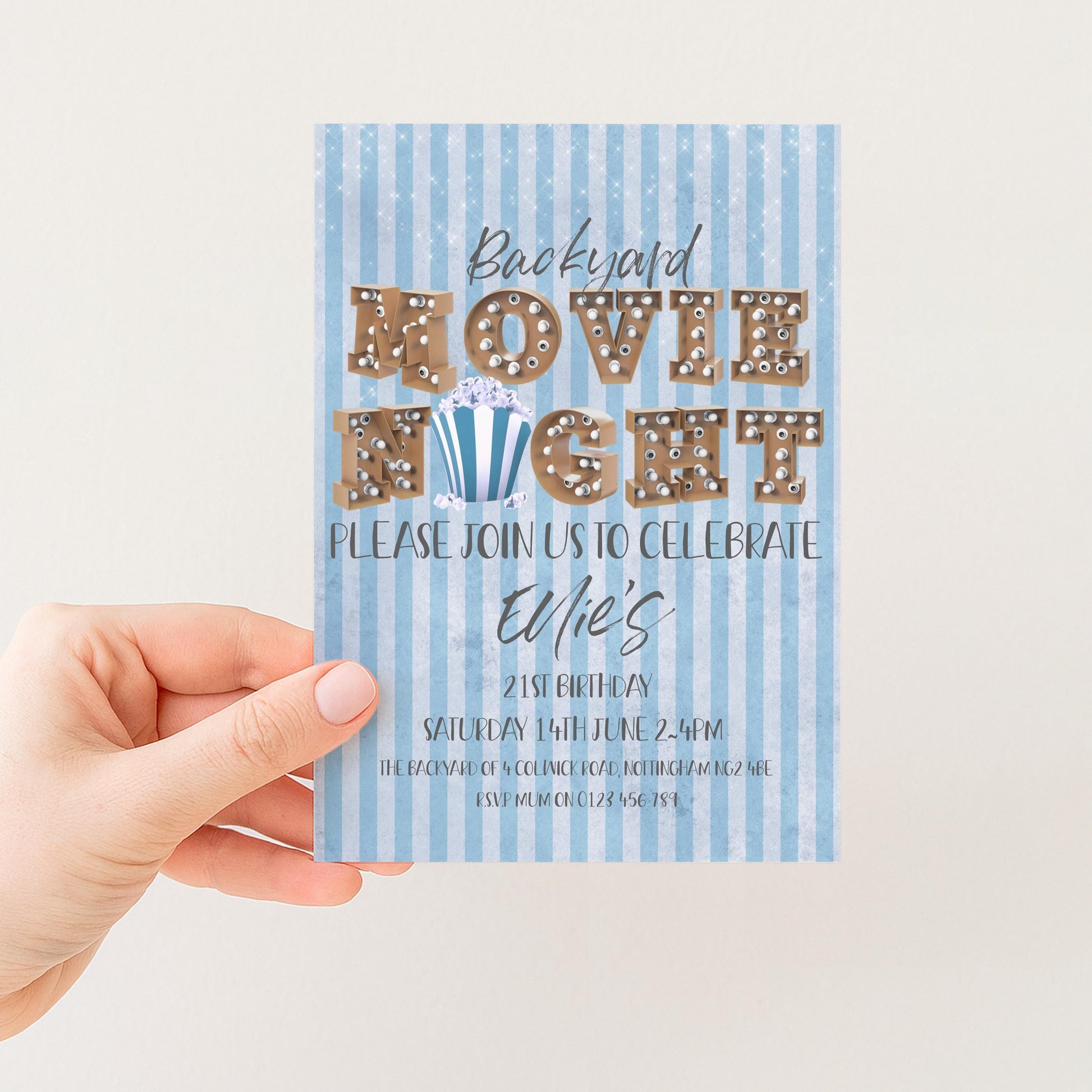 The image is a hand holding a blue and white striped invitation card for a backyard movie night.