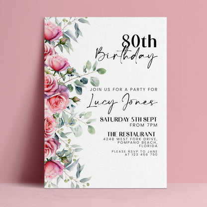 The image is a birthday invitation for a woman named Lucy Jones celebrating her 80th birthday. The invitation is set against a pink background and features a floral design with pink roses and greenery.