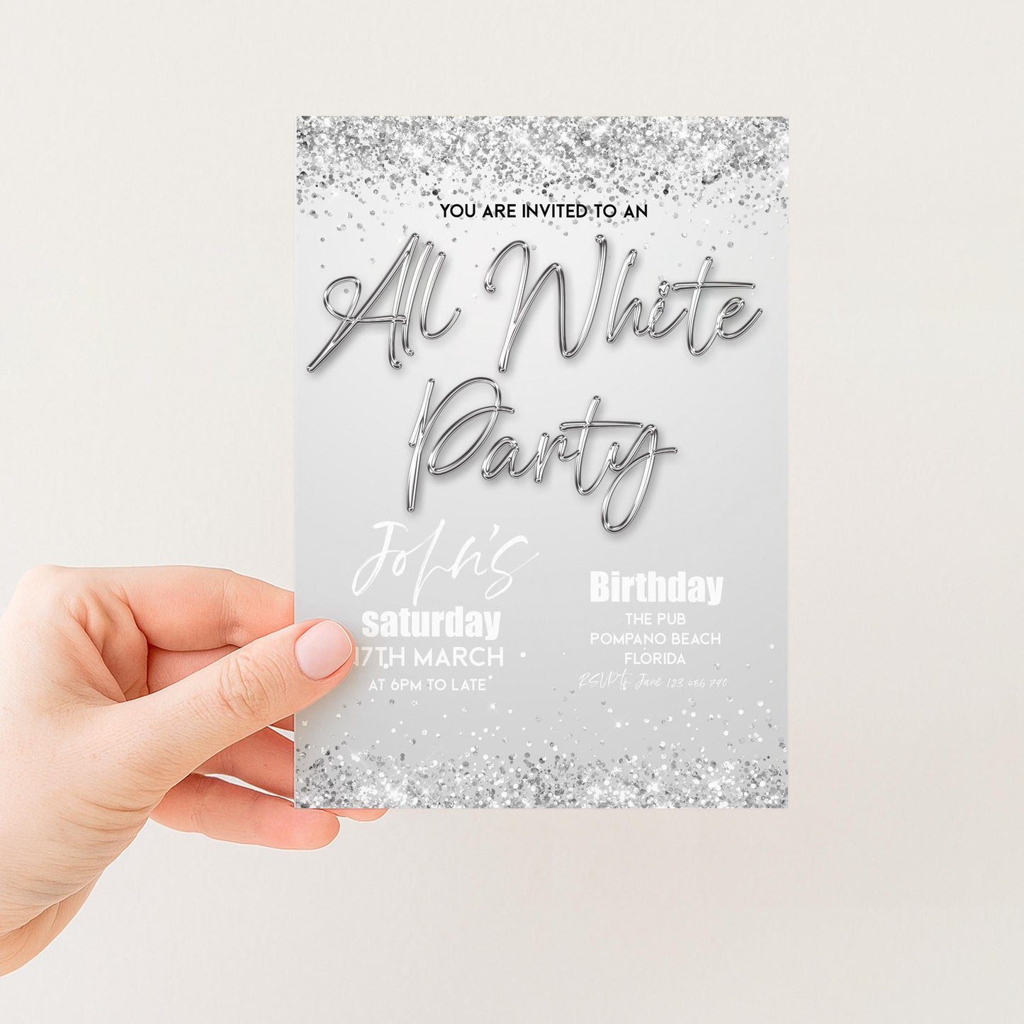 a hand holding a party invitation card with a silver glitter design.
