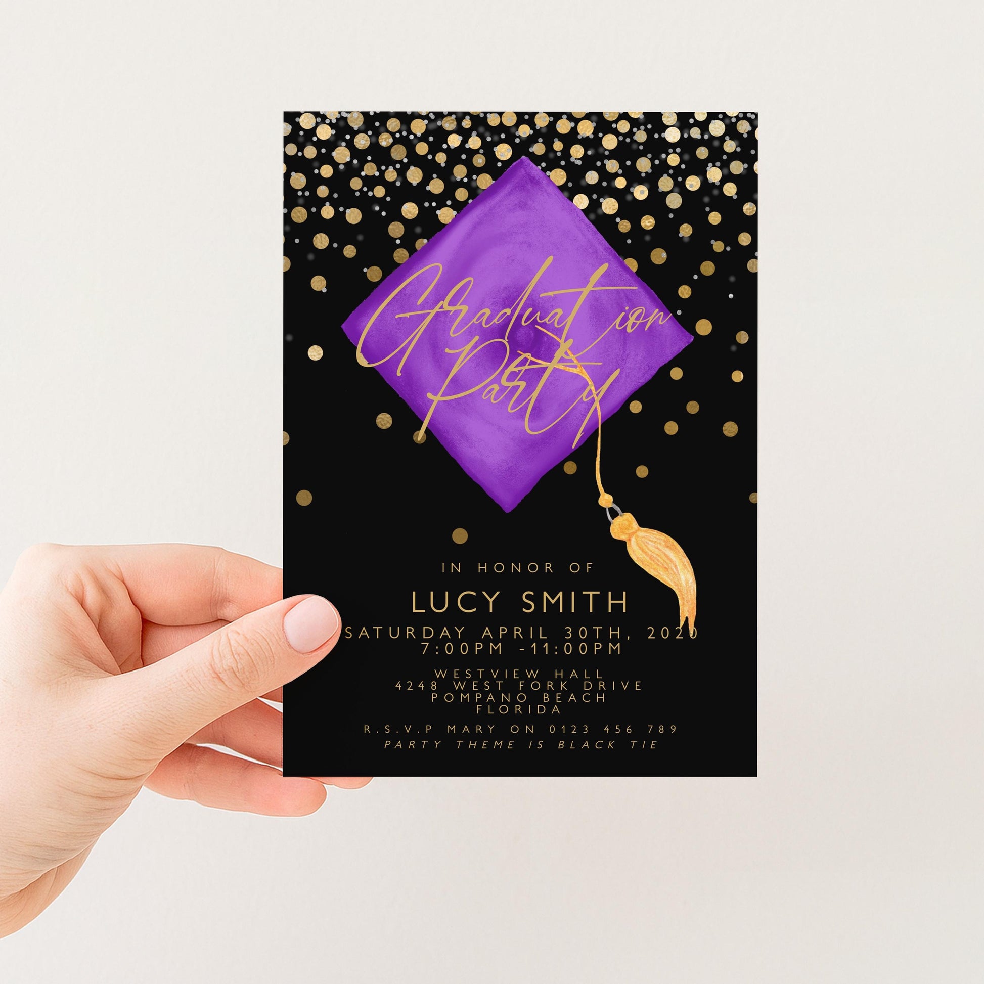 a hand holding a graduation party invitation card.