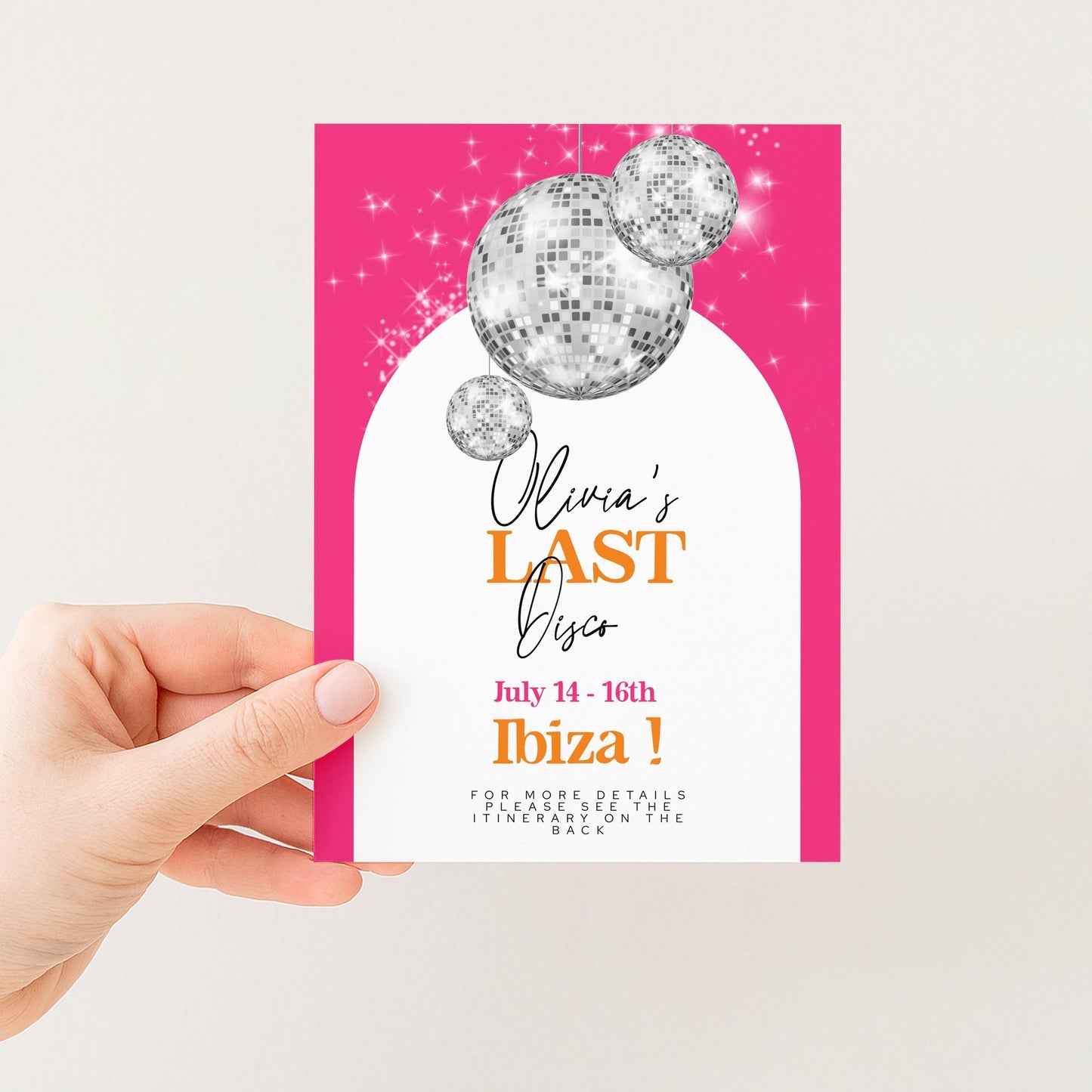 A hand holding a pink invitation card with a disco ball design and text announcing an event.