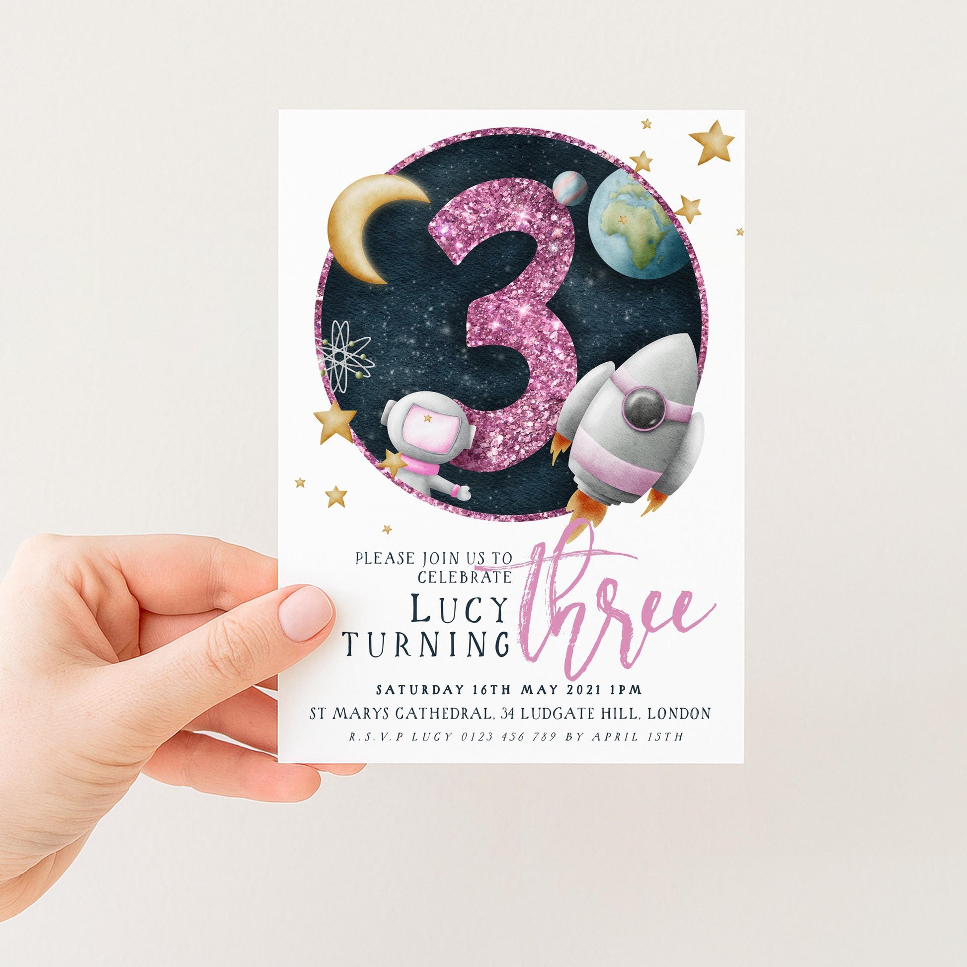 The image is a birthday invitation for a girl named Lucy turning three. It features a space theme with a rocket ship, a planet, and stars. The invitation is for a celebration on Saturday, May 14th, 2021, at St. Mary's Cathedral, London.