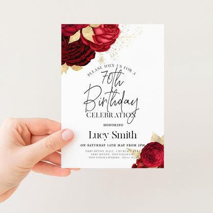 a hand holding a white invitation card with a floral design and text.