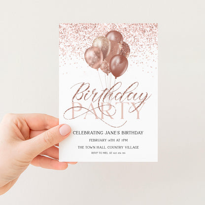 a hand holding a birthday party invitation card with a pink and gold color scheme. The card features a design of pink and gold balloons floating above the text "Birthday Party" and "Celebrating Jane's Birthday".