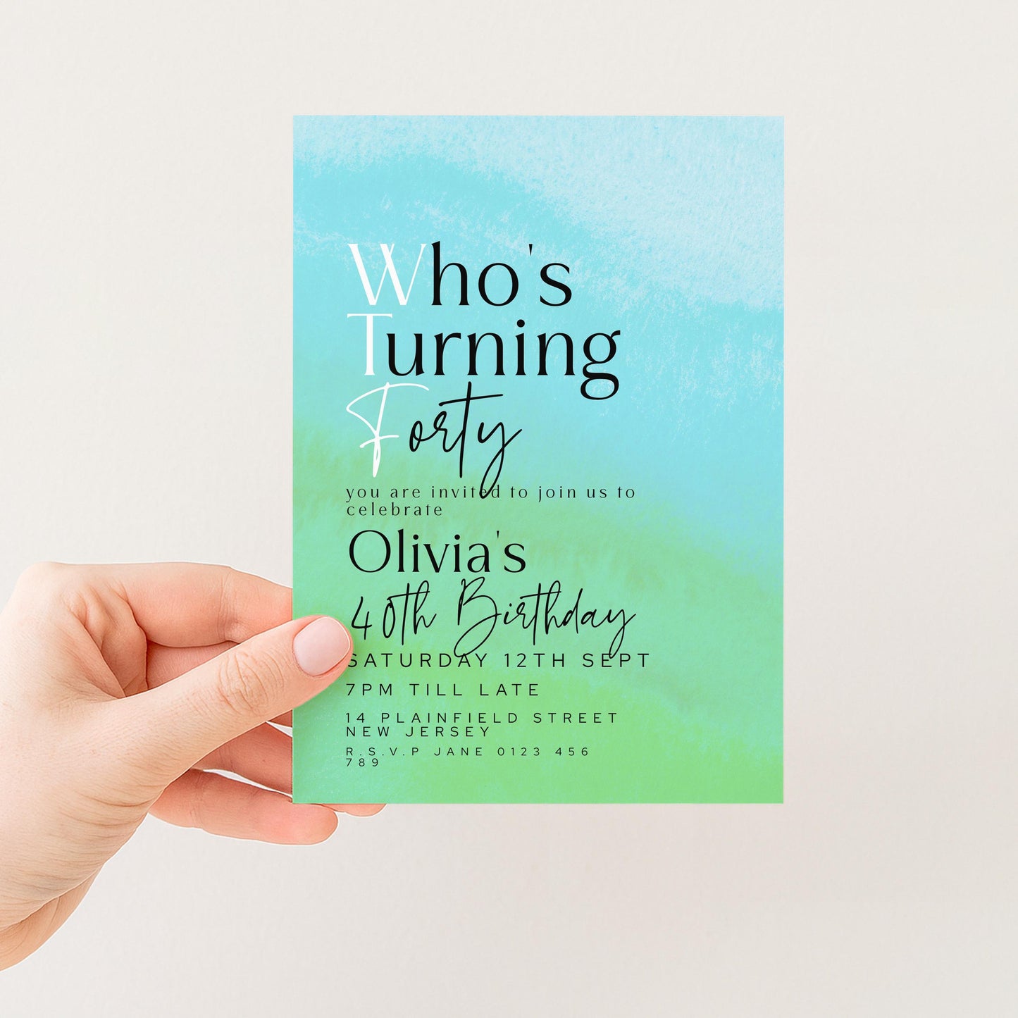 a hand holding a blue and green birthday invitation card.