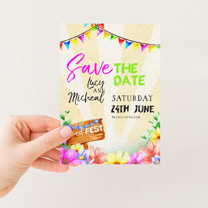A hand holding a colorful wedding invitation card with text and decorative elements.
