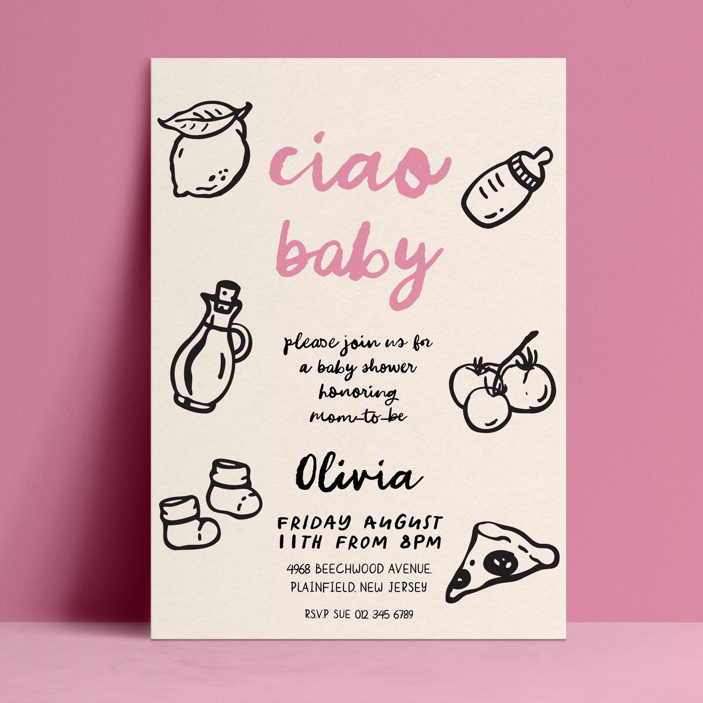 The image is a baby shower invitation featuring a pink background with black text and illustrations of baby-related items such as a bottle, a lemon, and baby socks.