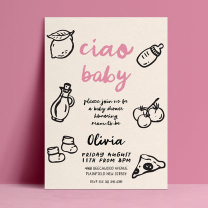 The image is a baby shower invitation featuring a pink background with black text and illustrations of baby-related items such as a bottle, a lemon, and baby socks.