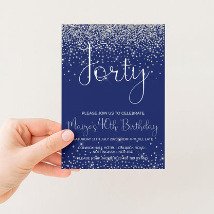 a hand holding a blue birthday invitation card with a glittery design.