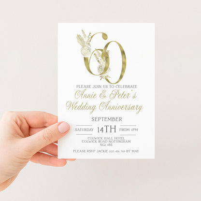 a person holding a wedding anniversary invitation card.