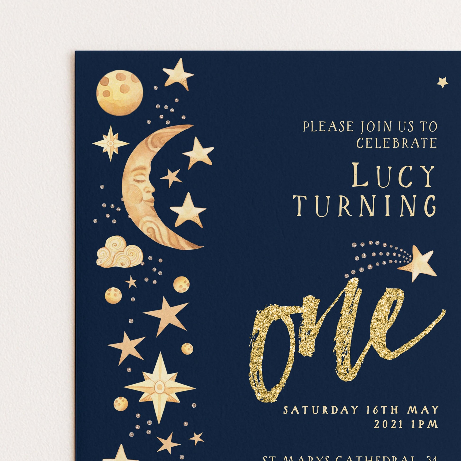 The image is a birthday invitation for a girl named Lucy, who is turning one. The invitation features a dark blue background with gold stars and a crescent moon, along with the text "Please join us to celebrate Lucy Turning".