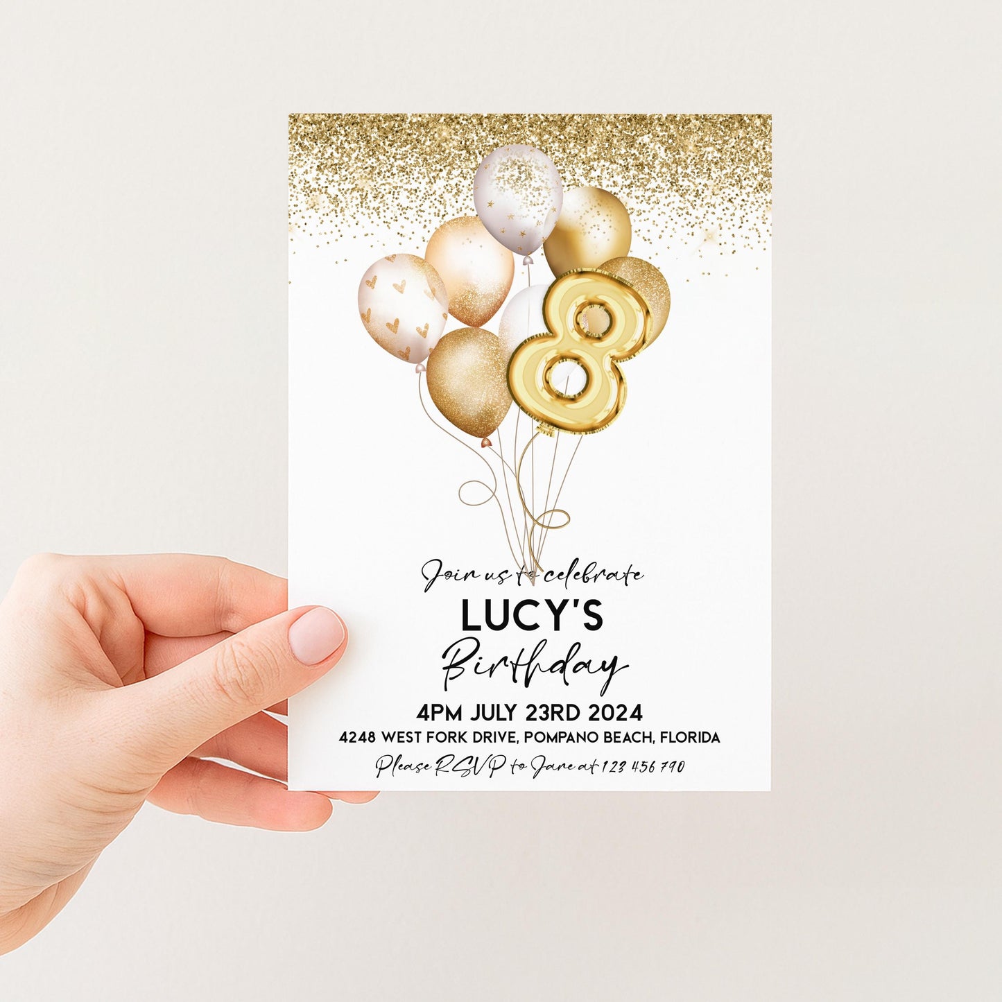 a person holding a birthday invitation card with a birthday celebration theme. The card features gold balloons and confetti, and the text invites guests to join the celebration of Lucy's birthday.