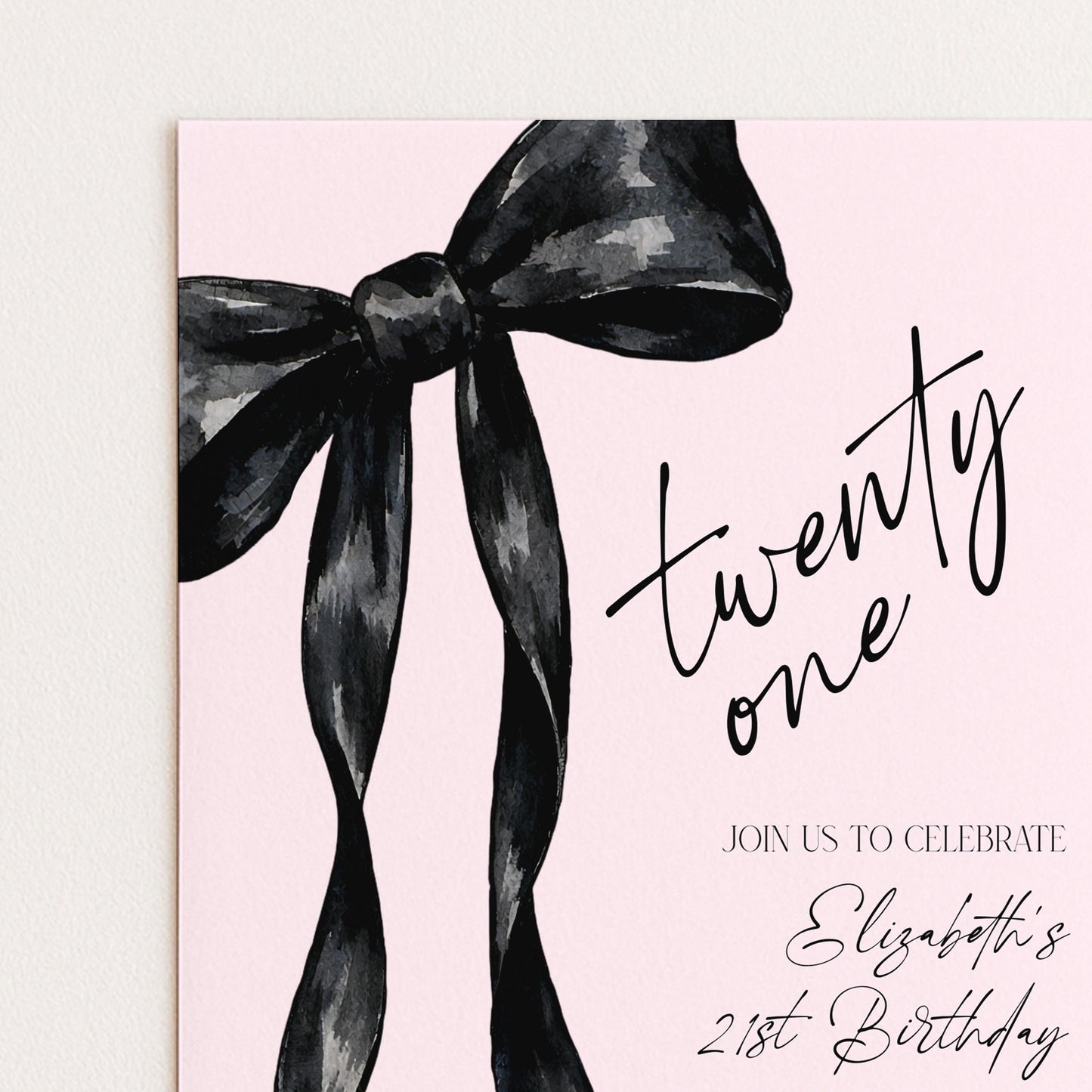 a pink background with a large black bow and the text "twenty one" written in a cursive font.