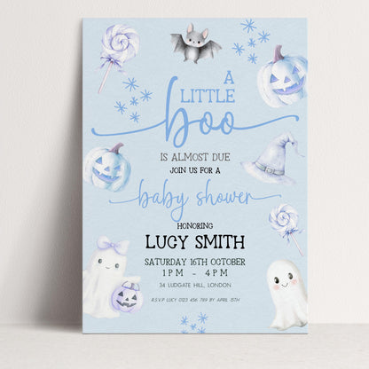 A baby shower invitation featuring a light blue background with illustrations of bats, pumpkins, and ghostly figures.