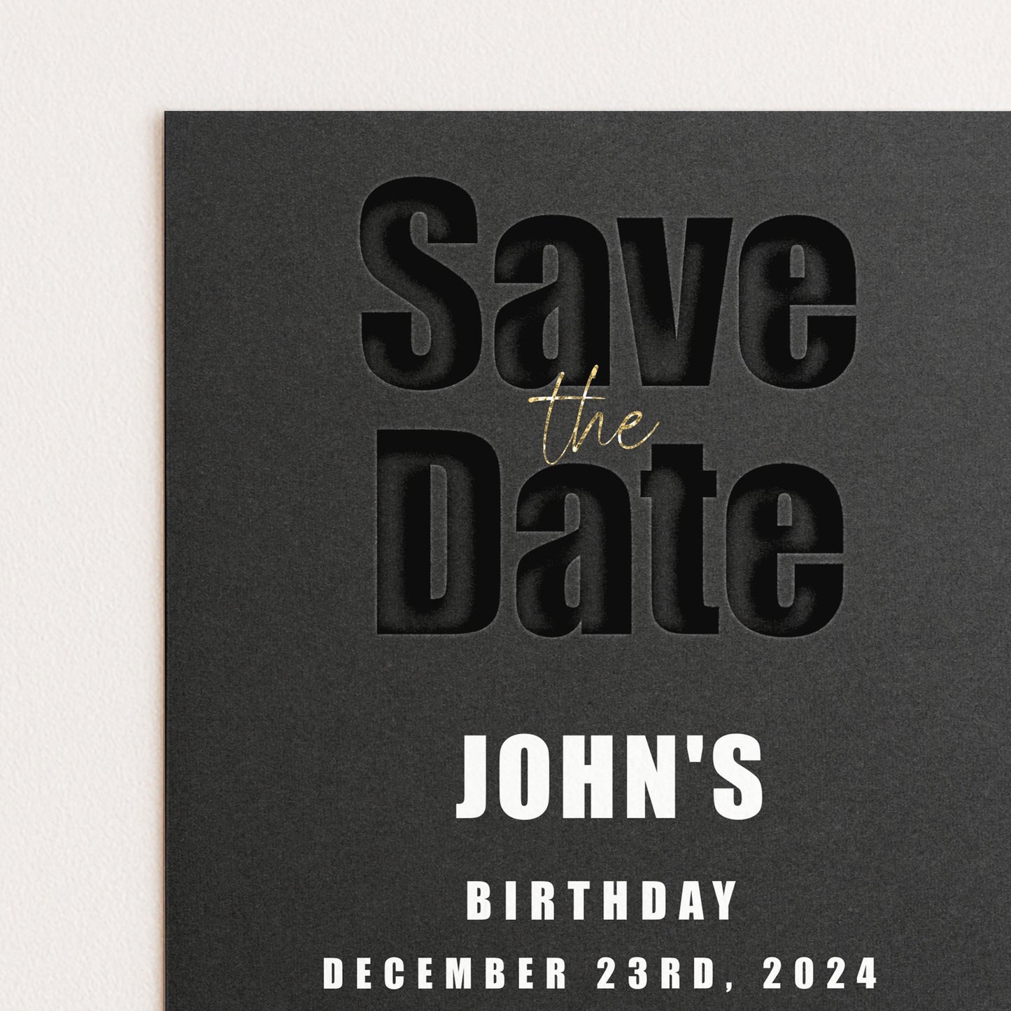 The image is a black and white photograph of a save the date card for John's birthday.