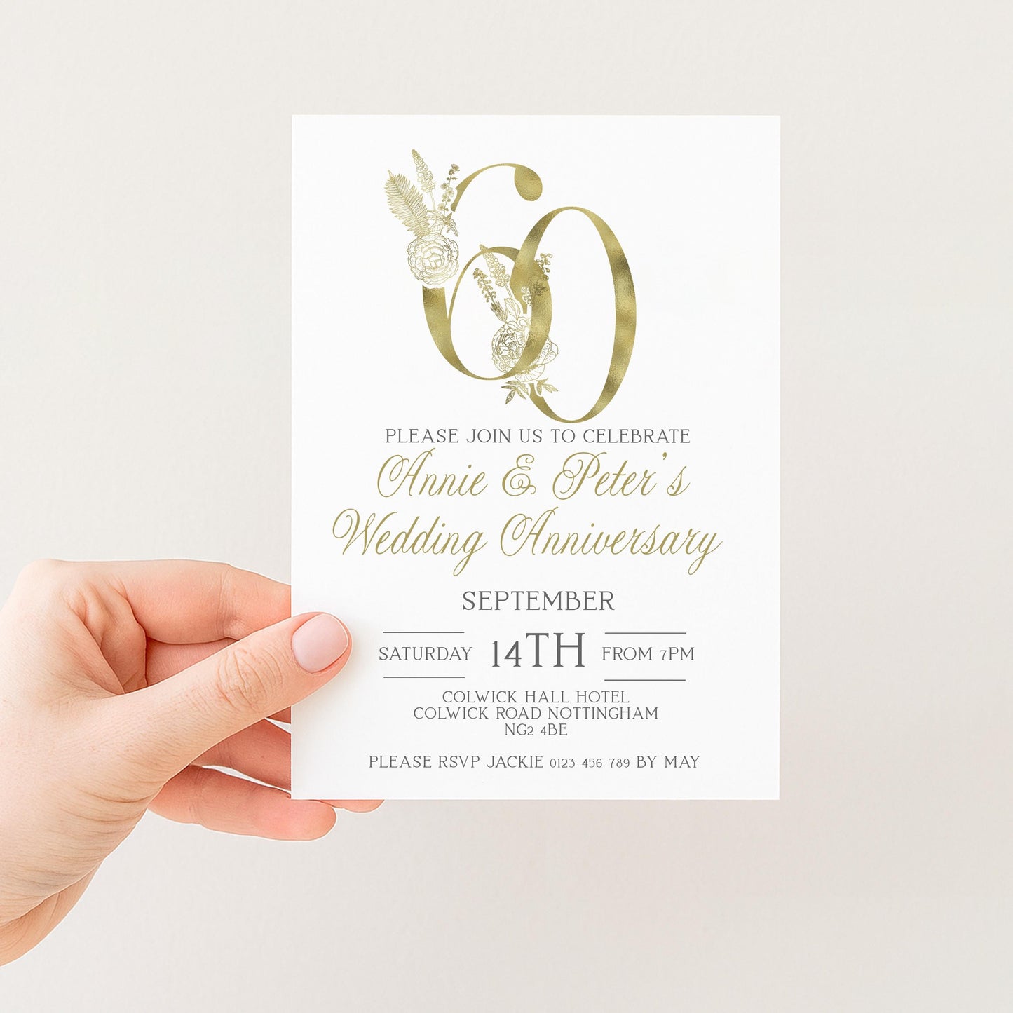 a person holding a wedding anniversary invitation card.