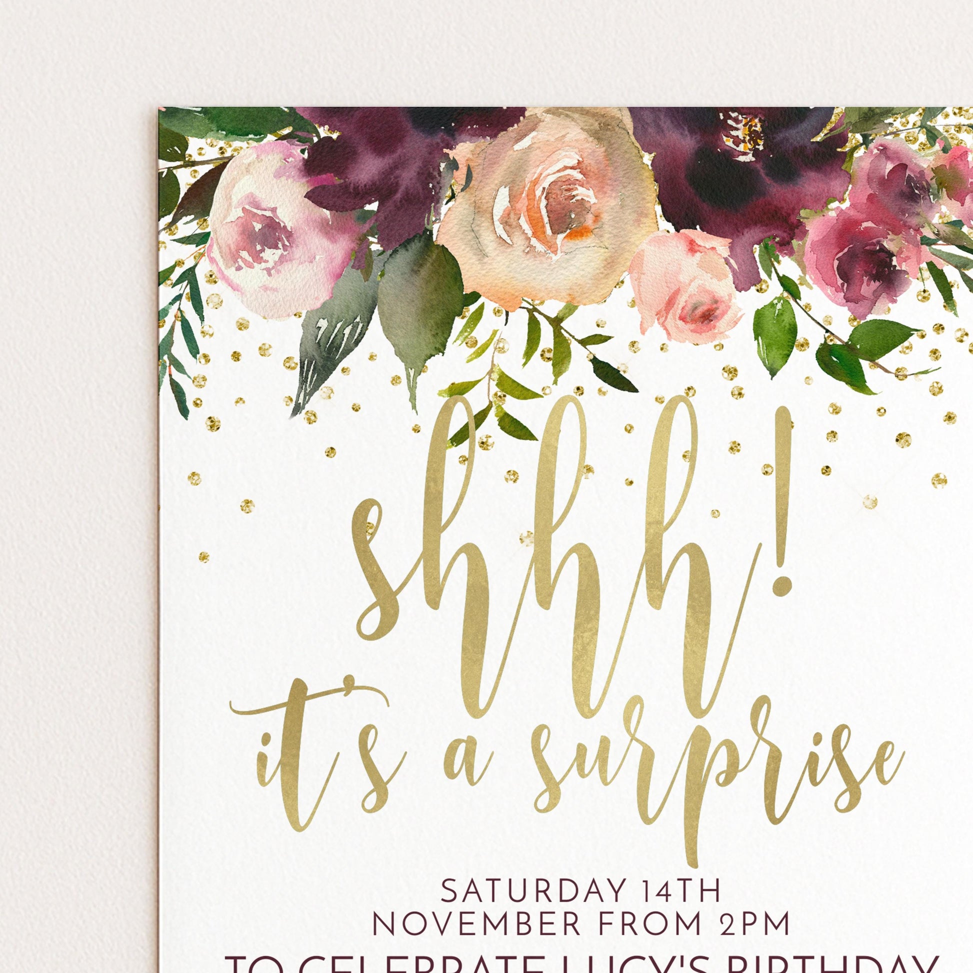 A birthday party invitation with a floral design and the text "shhh! it's a surprise" in gold lettering.