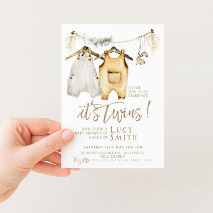 The image is a hand holding a baby shower invitation card.