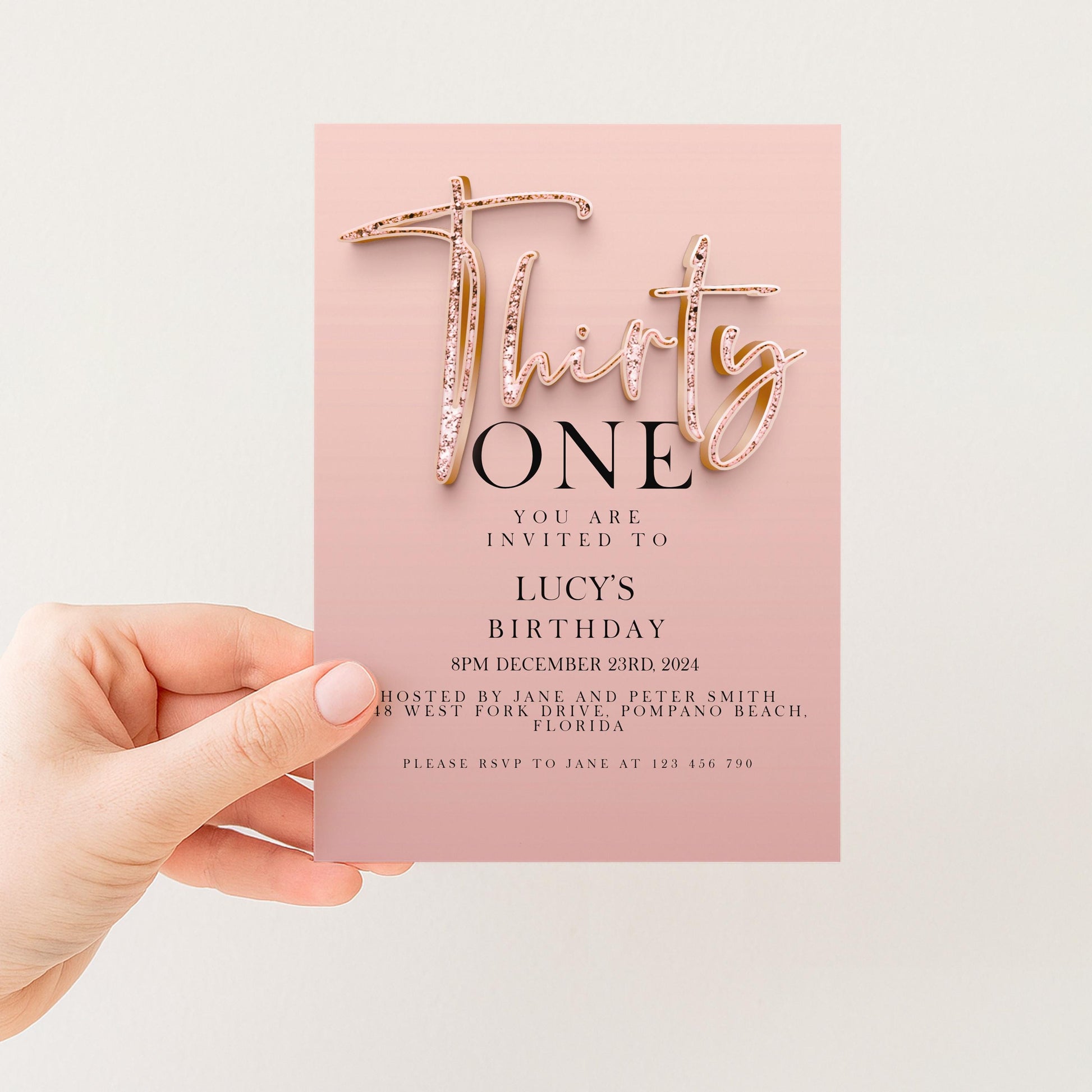 a hand holding a pink birthday invitation card with text and details about a birthday party.