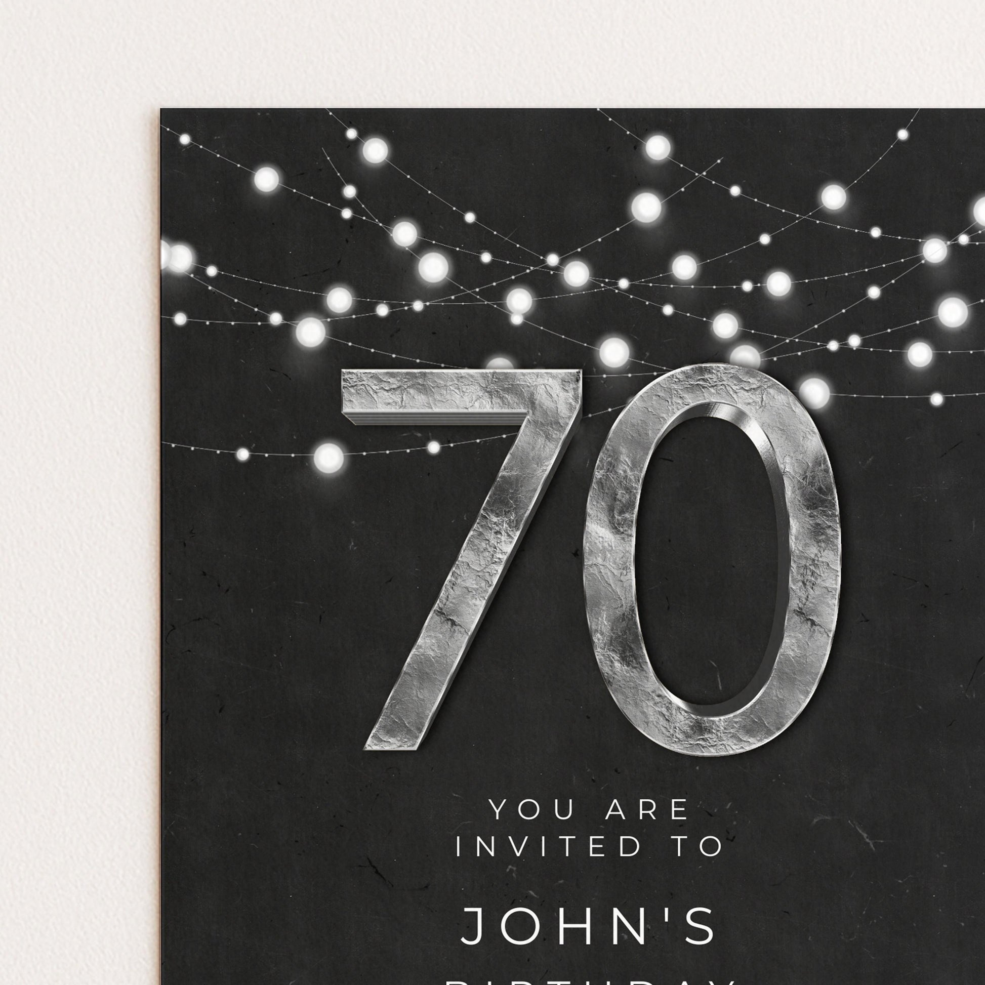 The image is a birthday invitation for John's 70th birthday, featuring a large number "70" and a string of white lights.