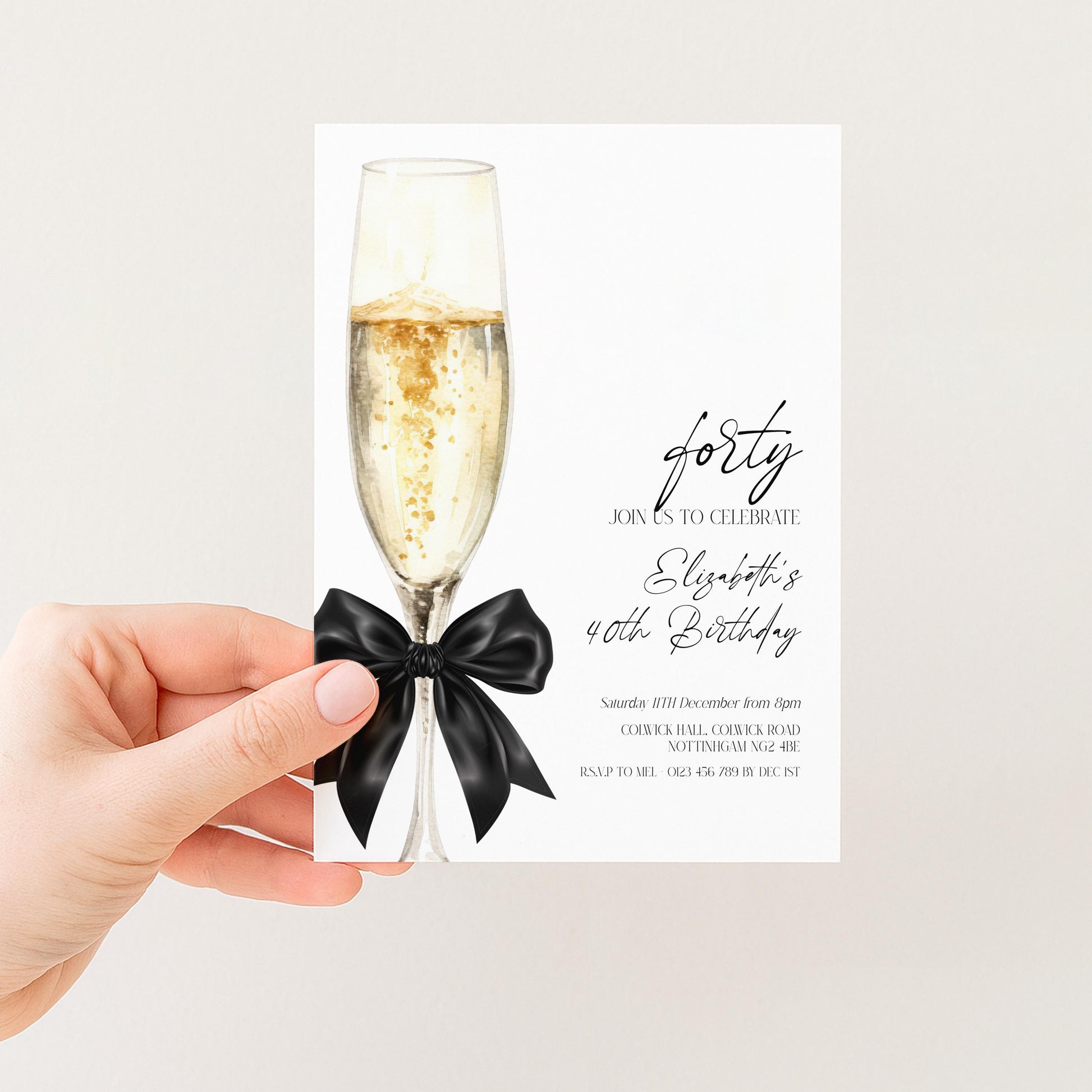a hand holding a card with a champagne glass and a black ribbon, which appears to be a birthday invitation or celebration card.
