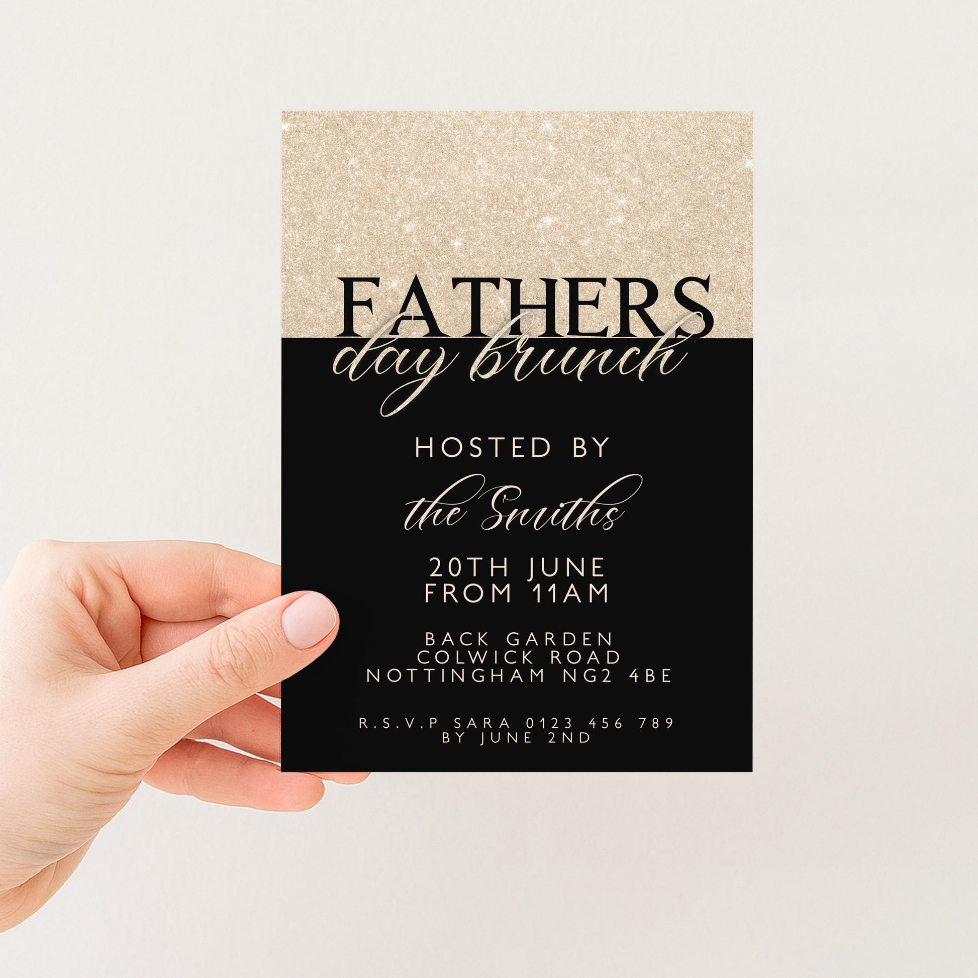 a hand holding a black and gold invitation card for a Father's Day brunch.
