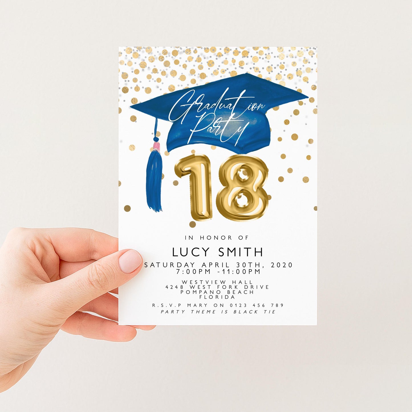 a person holding a graduation party invitation card.