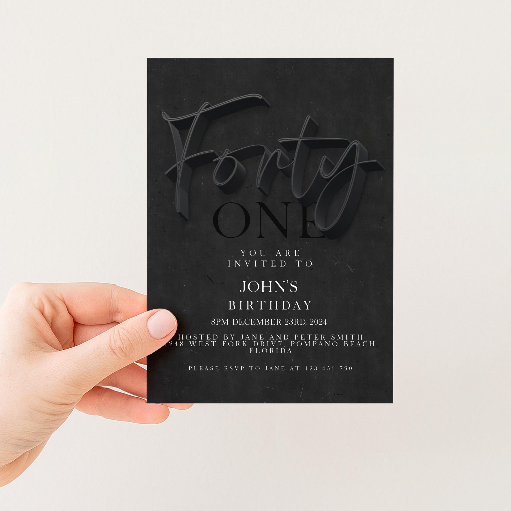 a person holding a black invitation card with text and details about a birthday party.