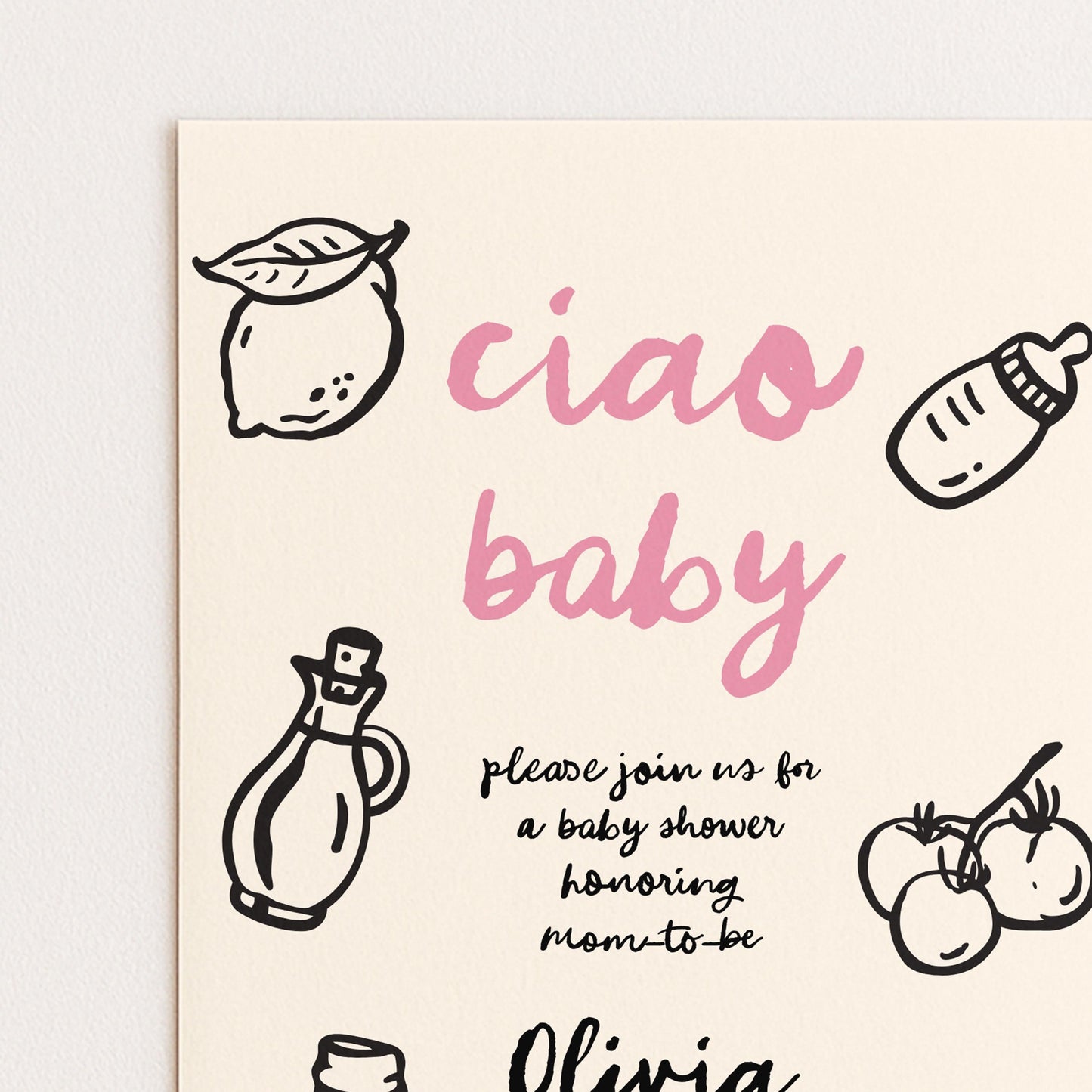 The image is a baby shower invitation featuring a pink and black color scheme with various baby-related items such as a bottle, a lemon, and tomatoes.