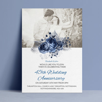 A black and white photograph of a couple embracing, with a floral design above them. The text below the image announces a 45th wedding anniversary celebration.