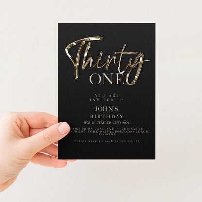 a person holding a black invitation card with gold text and details about a birthday party.