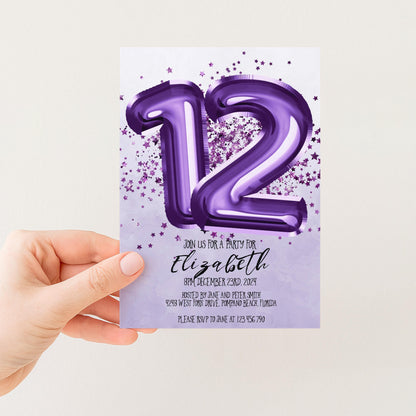 A hand holding a purple invitation card with the number 12 and stars on it.