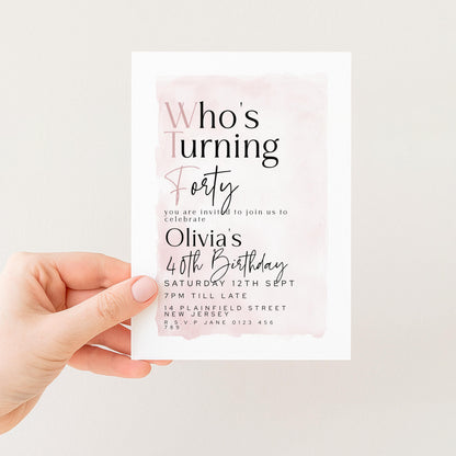 a hand holding a white invitation card with text and details about an upcoming birthday celebration.
